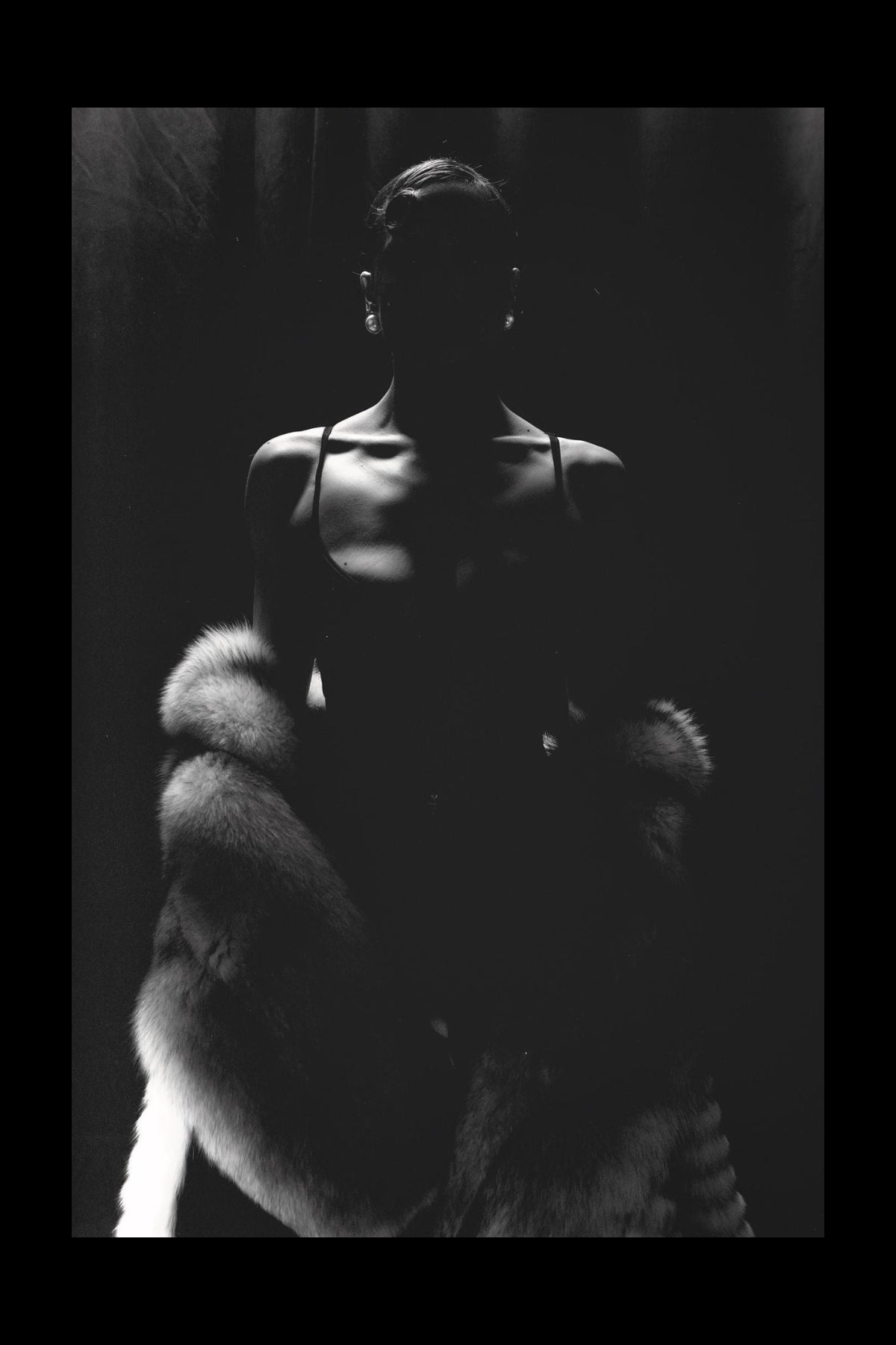 Person wearing a fur coat in a dark setting
